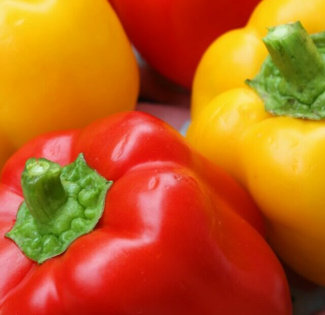 red and yellow bell peppers in brown woven basket