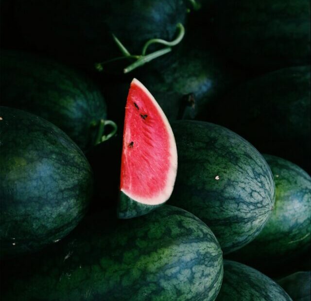 a pile of watermelon with a slice cut out of it