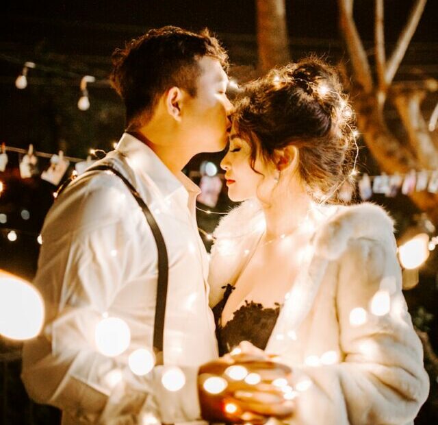 man kissing woman's forehead