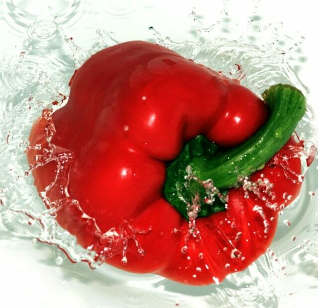 a red pepper with a green pepper on top of it