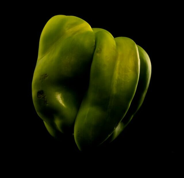 a green vegetable with a black background